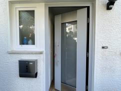 Haustür gräulich mit breiten Milchglas-Lichtausschnitt geöffnet